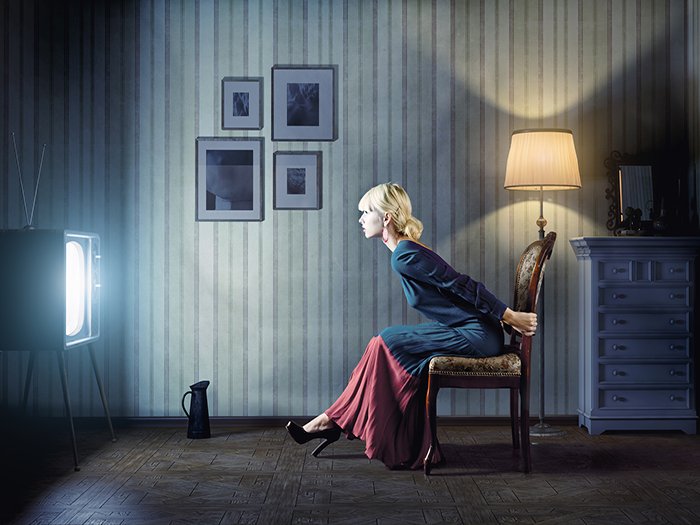 Woman watching TV in blue dress